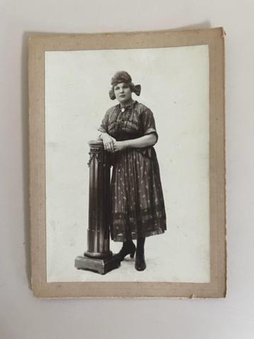 Grote antieke foto. Vrouw die tegen een zuil aanstaat.