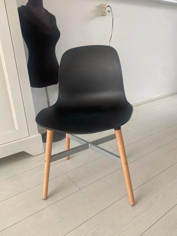 Zwarte kunststof stoel met houten poten beschikbaar voor biedingen