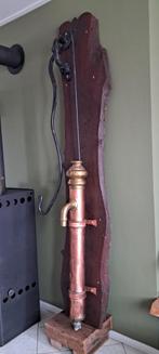 Decoratieve oude koperen pomp op houten paneel, Ophalen