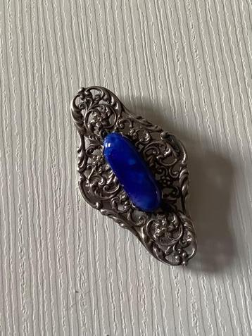 Langwerpige zilveren broche bezet met korenblauwe steen. beschikbaar voor biedingen