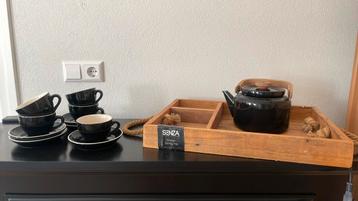 Houten dienblad met zwarte theepot en kop en schotels beschikbaar voor biedingen