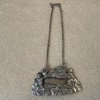 Rijk gedecoreerde karaf label van zilver met o.a. engeltjes, Antiek en Kunst, Antiek | Goud en Zilver, Verzenden, Zilver