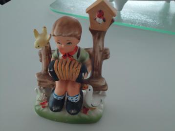 beeldje jongetje op bankje met vogeltje en vogelhuisje en ga beschikbaar voor biedingen