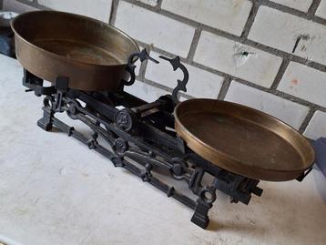 Oude gietijzeren weegschaal met 2 koperen schalen beschikbaar voor biedingen