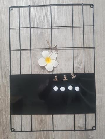 Zwart memobord met magneetjes, clipjes en bloem
