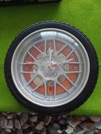 Wandklok in de vorm van een autoband-defect, Huis en Inrichting, Woonaccessoires | Klokken, Ophalen of Verzenden, Gebruikt, Analoog
