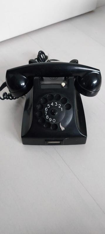 Oude zwarte telefoon met draaischijf beschikbaar voor biedingen