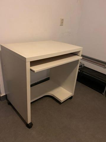 bureau met wit wieltjes uitschuifbaartoetsenbord