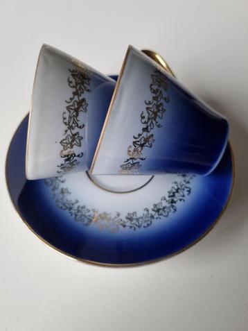 Blauw setje kop en schotels met goudkleurig randje beschikbaar voor biedingen