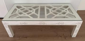 Salontafel met glazen tafelblad op witte houten structuur beschikbaar voor biedingen