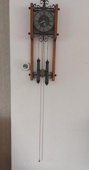 Antieke wandklok met gewichten beschikbaar voor biedingen