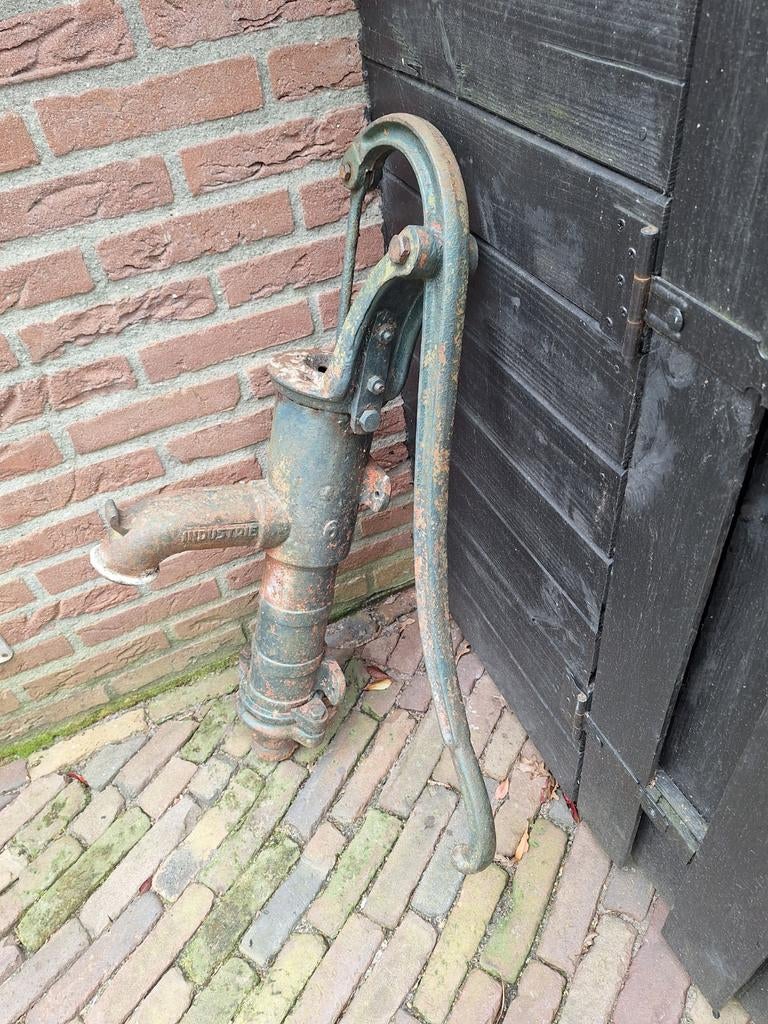 Antieke gietijzeren handwaterpomp., Ophalen