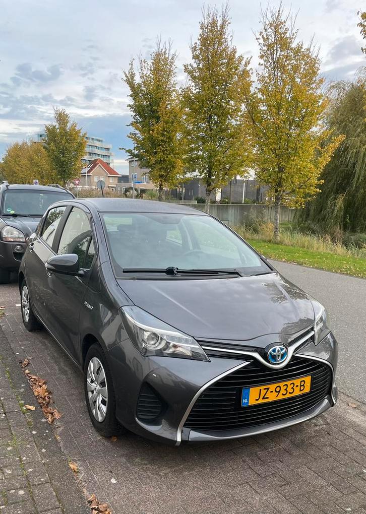 Toyota Yaris 1.5 Now - 2016 Grijs, Auto's, Toyota, Particulier, Yaris, Hybride Elektrisch/Benzine, Volledig hybride, A, Hatchback