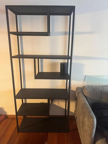 Zwarte metalen kast met vakken beschikbaar voor biedingen