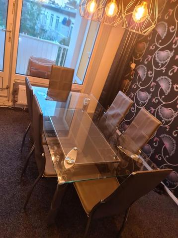 Glazen eettafel, zwarte leren poten,met 6 stoelen  beschikbaar voor biedingen