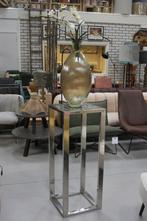 Metalen zuil met glazen vaas en kunst orchidee