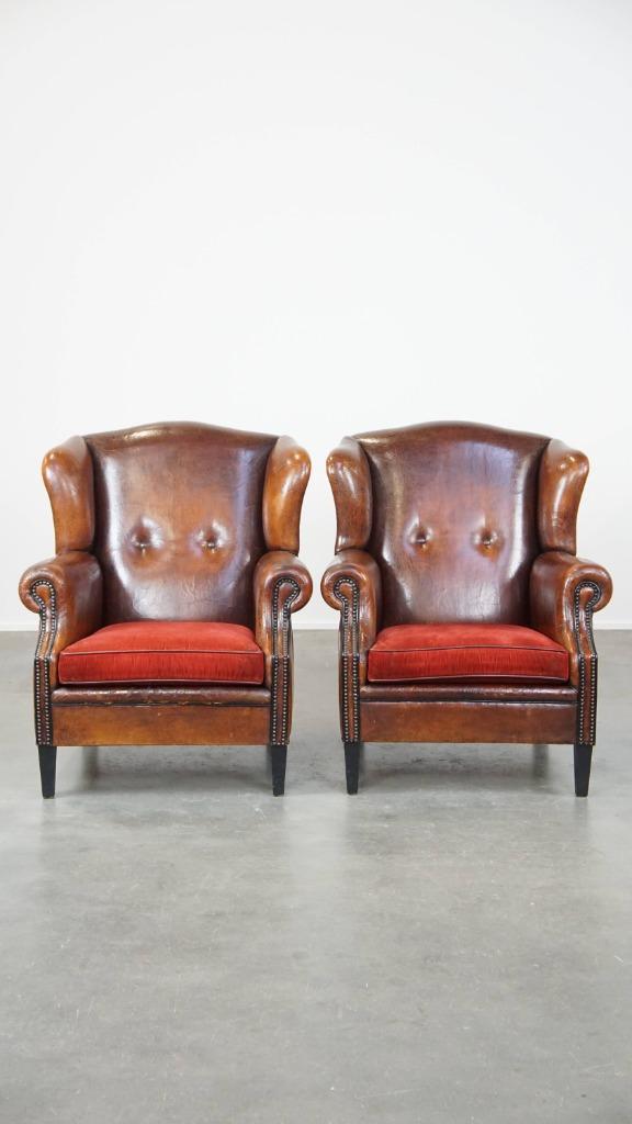 2 x Vintage schapenleren oorfauteuil met een rood zitkussen, Huis en Inrichting, Fauteuils, Gebruikt, Leer, Stof, 75 tot 100 cm