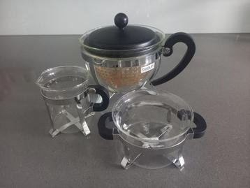Glazen theepot met suikerpotje en melk kannetje beschikbaar voor biedingen