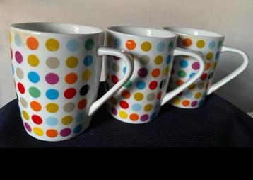 3 Mokken met rondom gekleurde stippen van AH. Hoogte 9 cm. beschikbaar voor biedingen