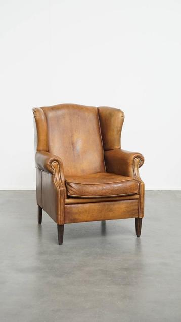 Karaktervolle vintage schapenleren oorfauteuil beschikbaar voor biedingen