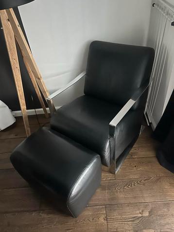 Zwarte leren fauteuil met voetenbank beschikbaar voor biedingen