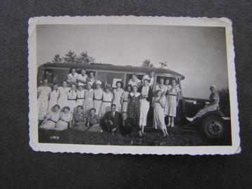 Kleine foto: Groep jonge vrouwen, bij / zittend op oude bus  beschikbaar voor biedingen