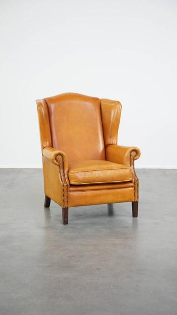 Comfortabele, luxe rundleren oorfauteuil met siernagels beschikbaar voor biedingen