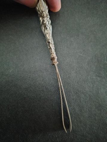 Antiek zilveren pincet met decoratie beschikbaar voor biedingen