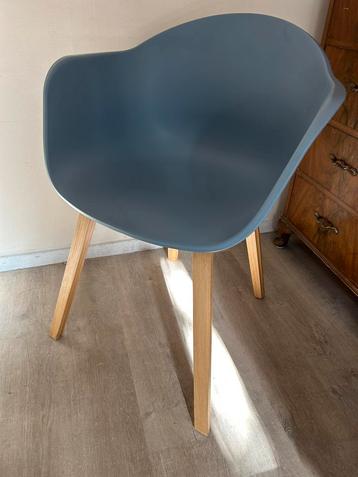 Armstoel van kunststof met houten poten beschikbaar voor biedingen