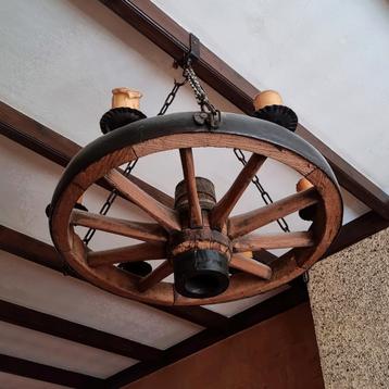 Middeleeuws karrewiel als kroonluchter met kaarsen beschikbaar voor biedingen