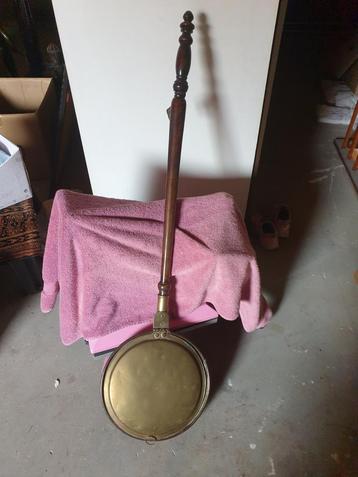 Antieke beddenpan met houten handvat beschikbaar voor biedingen