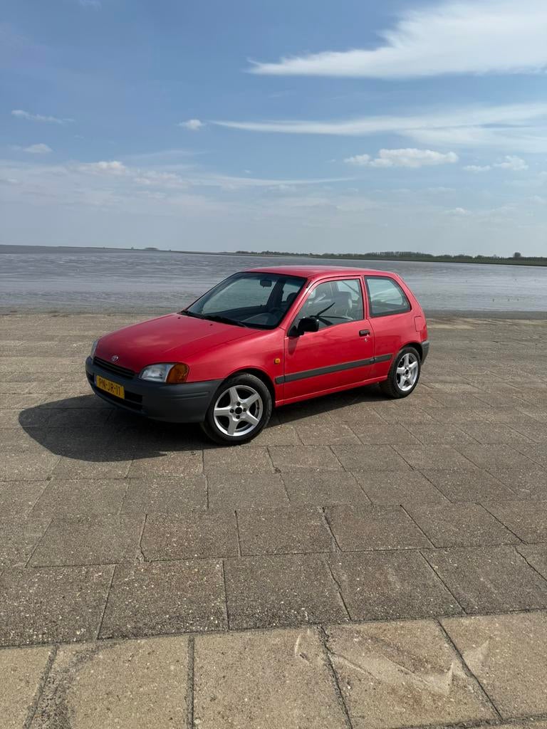 Toyota Starlet 1.3 16V 1996 Rood, Auto's, Toyota, Voorwielaandrijving, Stof, Radio, 4 cilinders