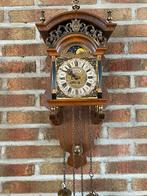 Ouderwetse hangklok met koperen gewichten, Ophalen