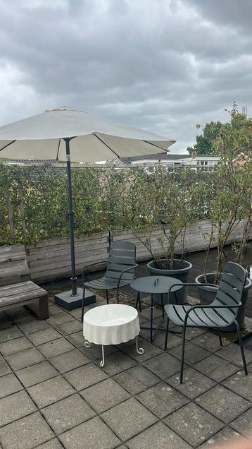 Leuke tuinstoelen met bijzettafeltjes en parasol met voet beschikbaar voor biedingen
