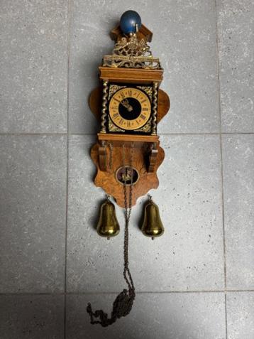 Antieke klok met romeinse cijfers en wereldbol figuur beschikbaar voor biedingen