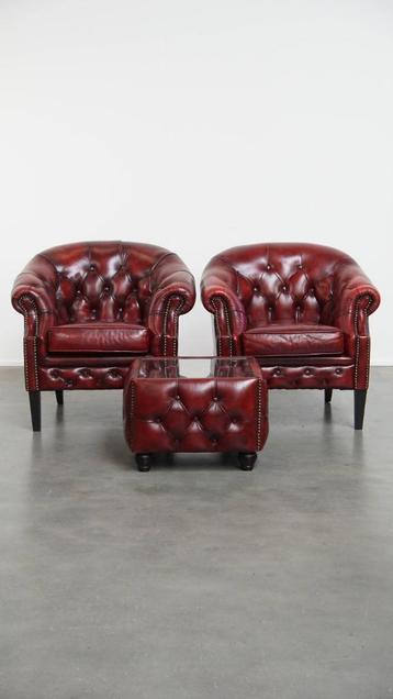 Rode rundleren chesterfield clubfauteuils en een bijzettafel beschikbaar voor biedingen