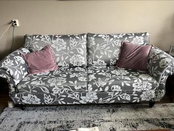 Grijze bank met bloemenprint 3-zits