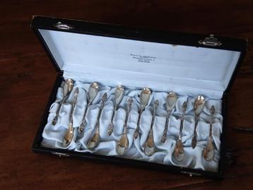  	12 zilveren advocaatlepels, mokkalepels, etui, eikeltjes 