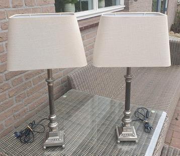Twee hoge metalen oudzilver kleurige lampen met beige kappen beschikbaar voor biedingen