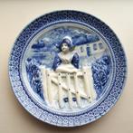 Muurplaat. Delfts blauw. In reliëf. Boerin leunend op hekje., Ophalen of Verzenden