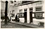 Brouwershofje in Haarlem met persoon voor een huisje., Ophalen of Verzenden, 1940 tot 1960, Ongelopen, Noord-Holland