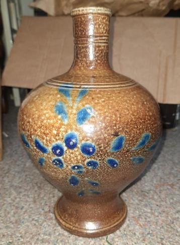 Oude bruine vaas met blauwe bloemen beschikbaar voor biedingen