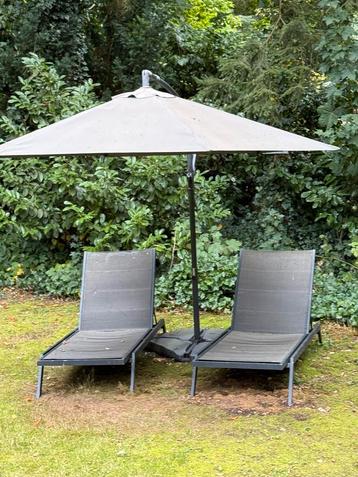 Twee Antracietkleurige ligbedden met kussens beschikbaar voor biedingen