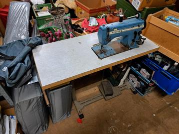 Industriële Singer naaimachine met tafel beschikbaar voor biedingen