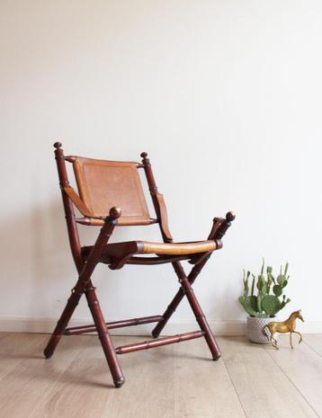 Houten vintage klapstoel. Antieke opvouwbare lederen stoel beschikbaar voor biedingen