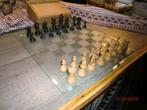 glazen schaakbord met houten schaakstukken en schaakboek, Hobby en Vrije tijd, Denksport en Puzzels, Schaken, Gebruikt, Ophalen of Verzenden