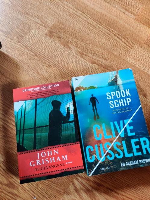 Clive Cussler - Spookschip en John Grisham - gevangene, Boeken, Thrillers, Zo goed als nieuw, Ophalen of Verzenden