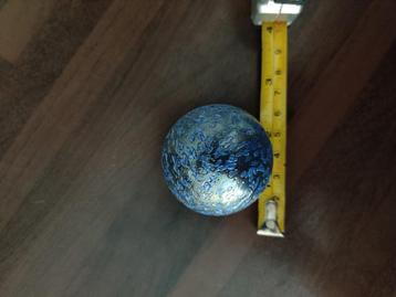Grote glazen knikker met blauwe spikkels beschikbaar voor biedingen