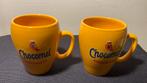 2 Geelkleurige mokken van Chocomel De Enige Echte. H.9,5 cm., Ophalen of Verzenden, Zo goed als nieuw, Gebruiksvoorwerp