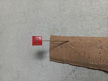 Metalen speldje van "Yoki" beschikbaar voor biedingen